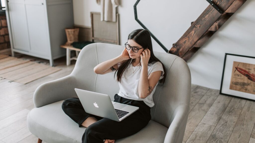 Frau alleine mit Laptop auf Sofa