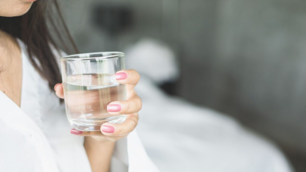 Frau trinkt ein Glas Wasser - Biohacking für Einsteiger