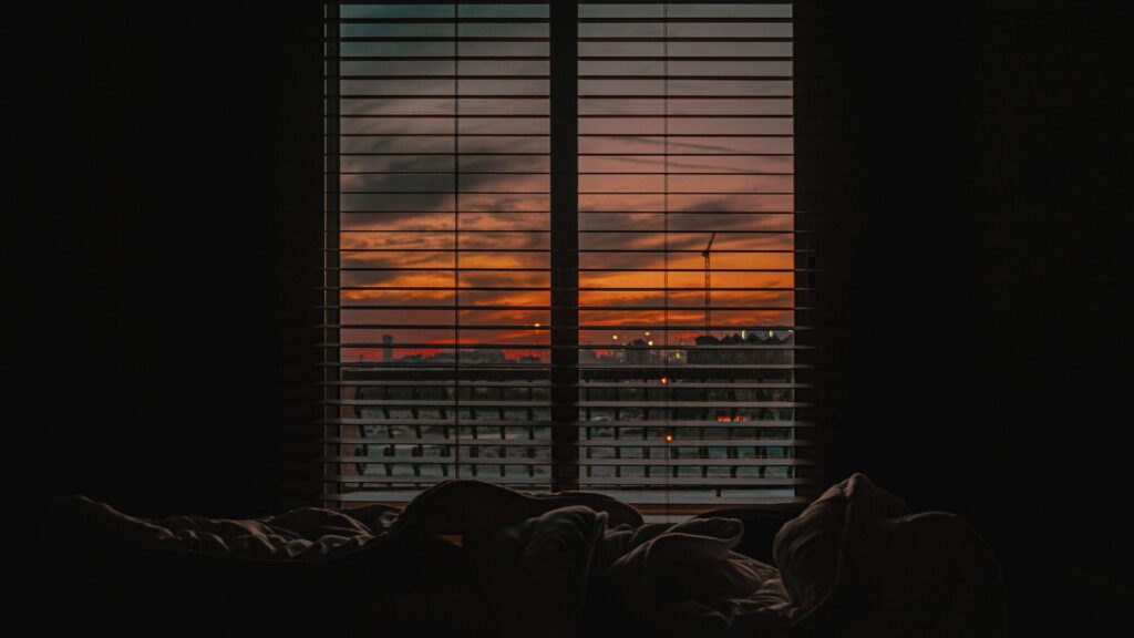 Minimalistisches Schlafzimmer bei Sonnenuntergang als Vorbereitung für besseren Schlaf