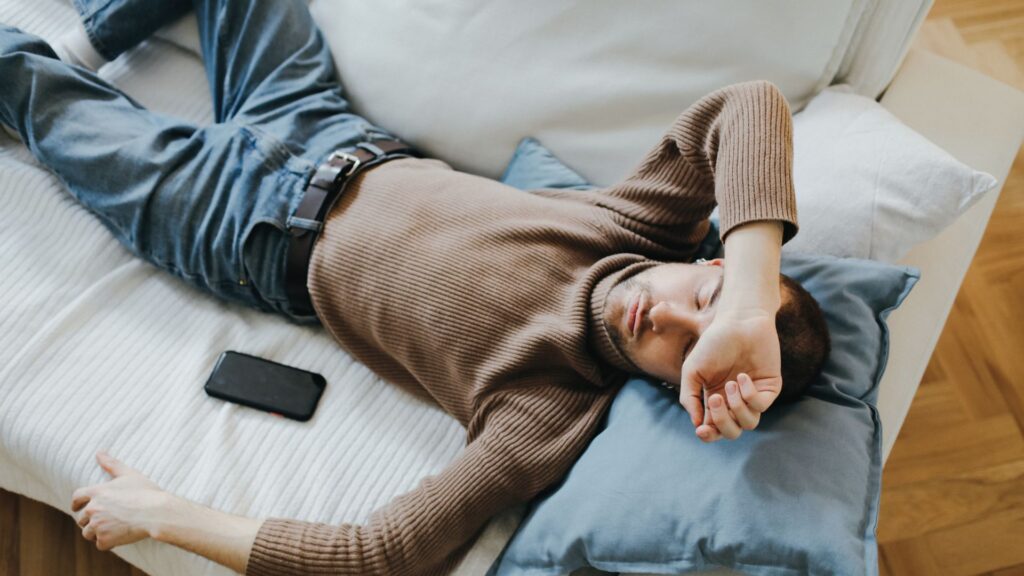 Person auf Sofa, erschöpft von zu viel Training