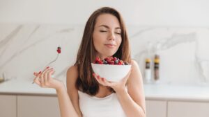 Frau genießt frische Beeren als gesunde, natürliche Mahlzeit – minimalistischer Ansatz für ausgewogene Ernährung