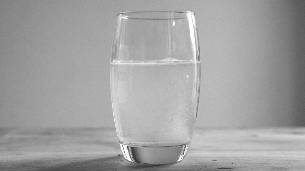 Frisch hergestelltes Wasserstoffwasser im Glas - sichtbar sprudelnd, direkt aus dem Elektrolysegerät, bereit zur Anwendung im Biohacking-Alltag