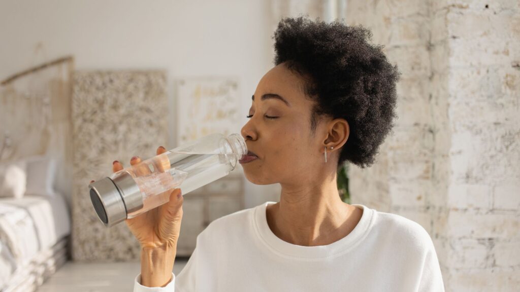Frau trinkt Wasserstoffwasser aus einer Booster Flasche