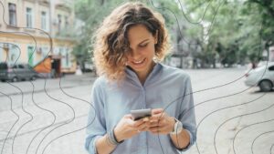Frau mit Smartphone in urbaner Umgebung, umgeben von symbolisierten EMF-Strahlen wie WLAN und 5G, bleibt dank schützendem Energiefeld ruhig und fokussiert – Darstellung der Wirkweise des Vivobase Move im Alltag