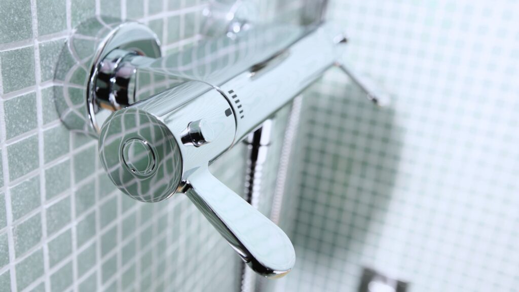 Kaltes Wasser läuft über modernen Duschkopf – Startpunkt einer kalten Dusche
