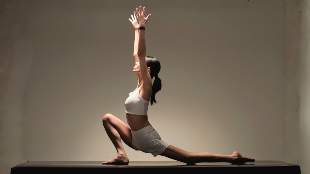 Sportlerin beim Yoga mit Fitnessarmband – elegante Nutzung des Polar Loop beim Training