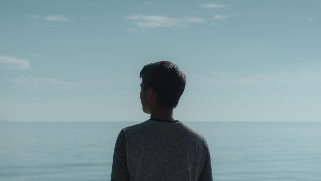 Person blickt ruhig aufs Meer als Sinnbild für mentale Klarheit und innere Ruhe