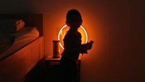 Kind steht vor warmer Abendbeleuchtung als Symbol für ruhige Schlafumgebung