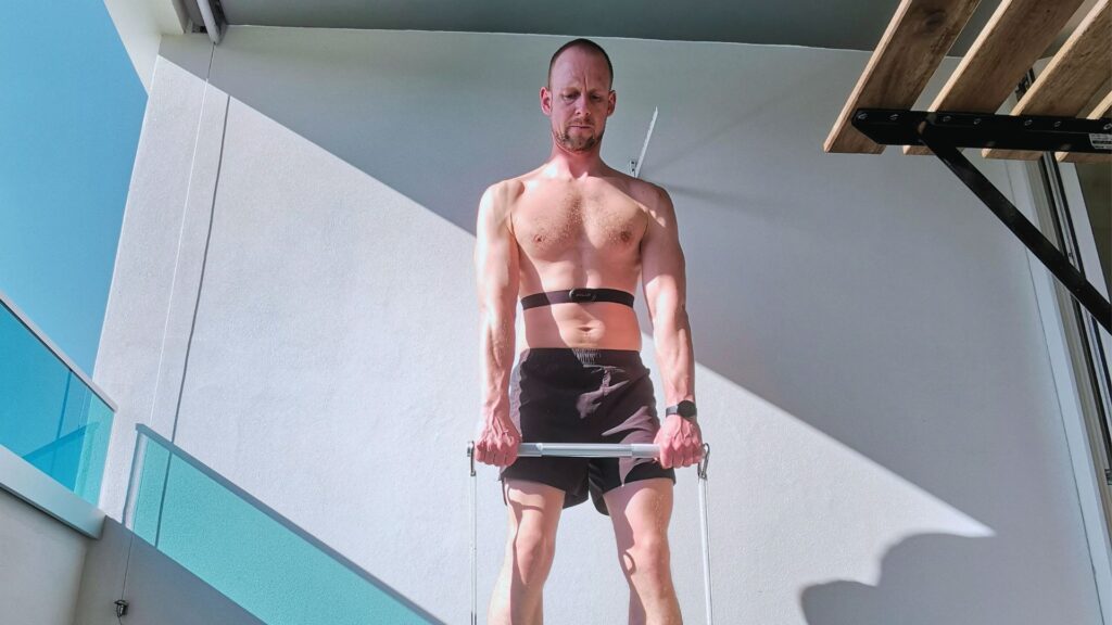 Mann trainiert im Freien und trägt eine Tracking Uhr und einen Brustgurt zur Trainingsmessung und Mann mit einem Brustgurt zur Herzfrequenzmessung und für sinnvolles Gesundheits-Tracking im Alltag