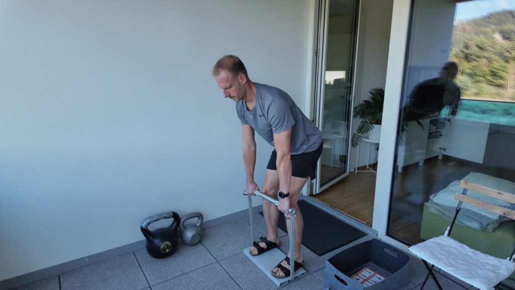 Mann trainiert zeitsparend mit variablen Gewichten auf Balkon